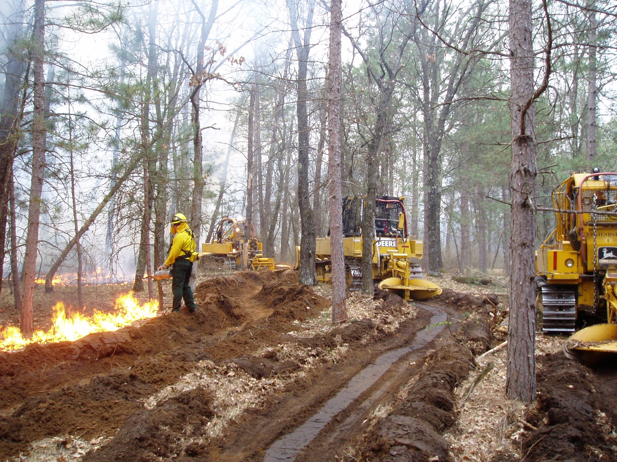 Tractor-plows digging furrows to contain a wildfire