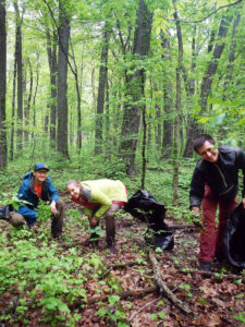 Photo showing volunteers smiling while they spend a busy day pulling garlic mustard from a Wisconsin forested area.