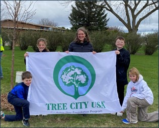 kids holding a Tree City USA banner