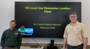 Two men in front of a PowerPoint main slide