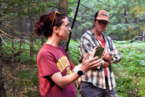 Two DNR workers discuss tree issues in the forest.